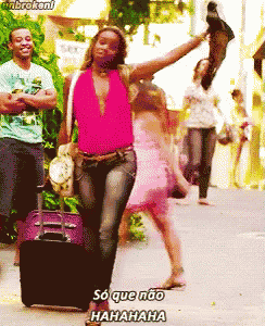 a woman in a pink top is walking down a street