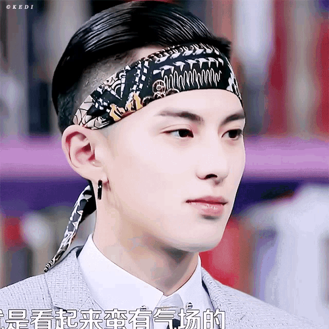a close up of a man wearing a headband with chinese writing