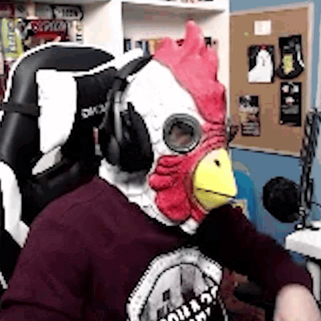 a person wearing a chicken mask and headphones is sitting in a chair .