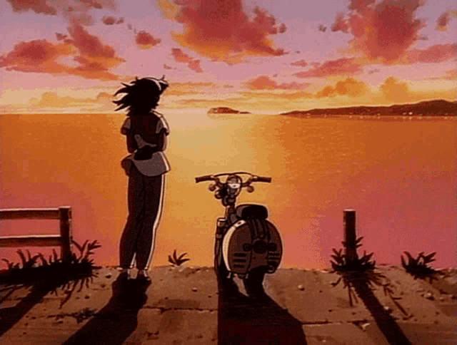 a woman standing next to a scooter looking at the ocean at sunset