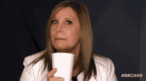a woman in a white jacket is holding a cup of coffee .