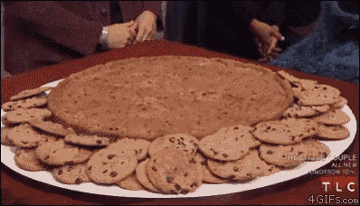 a tray of chocolate chip cookies with tlc written on the bottom