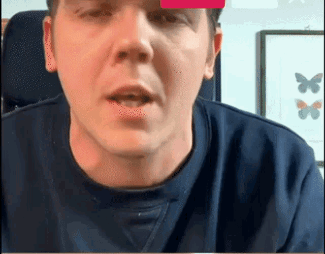 a man in a blue shirt is looking at the camera