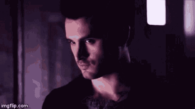 a close up of a man 's face in a dark room with a shadow on his face .