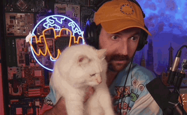 a man wearing headphones holds a white cat in front of a neon sign