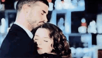 a man and woman are hugging each other with their eyes closed