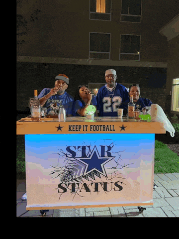 a group of people standing behind a bar that says " keep it football "
