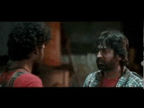 two men are talking to each other in a room .