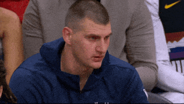 a man wearing a blue jacket with the word denver on the front
