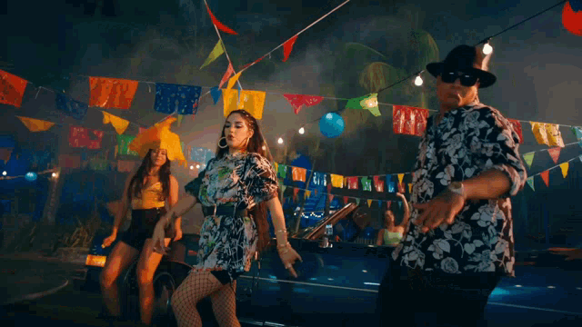 a man and a woman dancing in front of a car