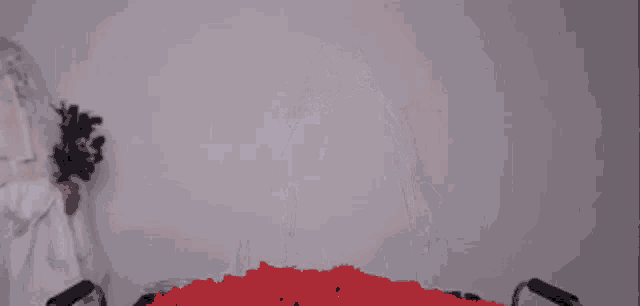 a ghost is standing in front of a pile of red candy .