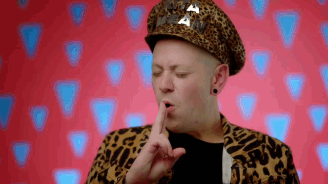 a man wearing a leopard print hat is making a shhh sign