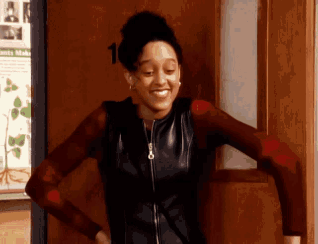a woman is standing in front of a door that has the number 1 on it
