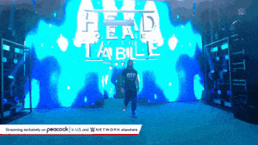 a man stands in front of a large screen that says head table