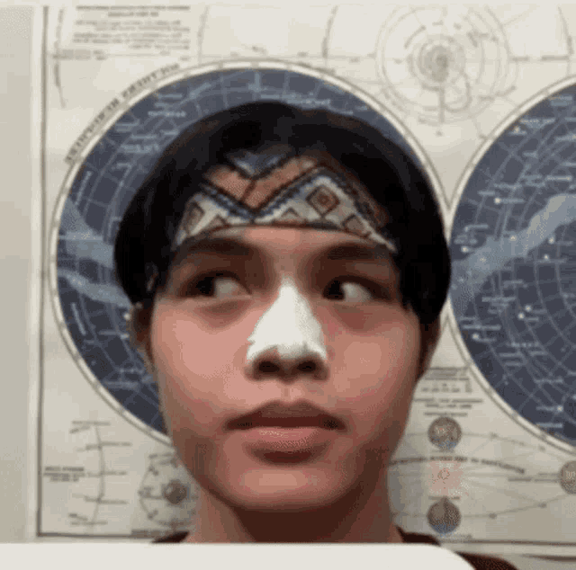 a young boy with a bandana on his head has a bandage on his nose