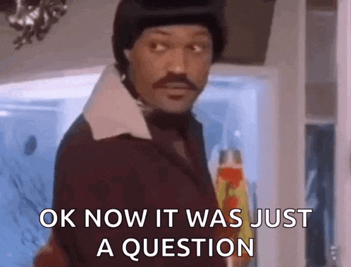 a man with a mustache is holding a lava lamp and says `` ok now it was just a question ''