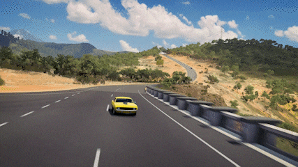 a yellow car is driving down a curvy road with mountains in the background