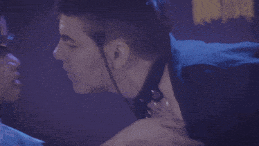 a man wearing glasses is kissing another man on the forehead