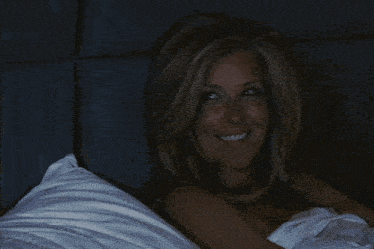 a woman laying in a bed with a blanket that says emily pill on it