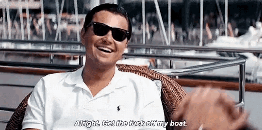 a man wearing sunglasses and a white shirt is sitting on a boat .
