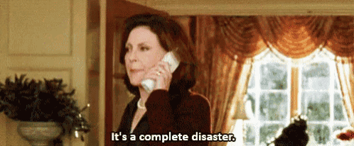 a woman is talking on a cell phone in a living room and saying `` it 's a complete disaster '' .