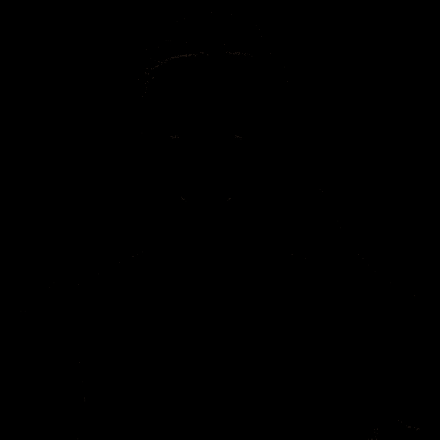 a man in a grey shirt looks at the camera with a black background