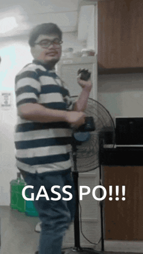 a man in a striped shirt is standing next to a fan with the words gass po written above him