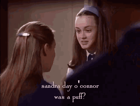 two girls are standing next to each other and talking to each other .