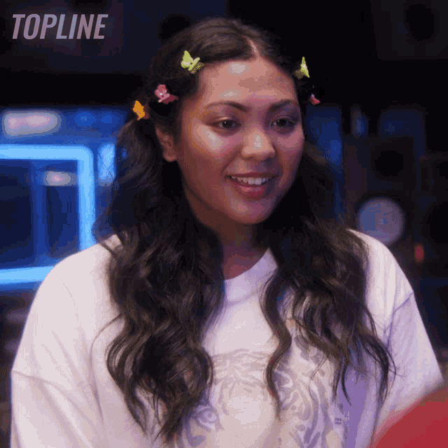 a woman is smiling in front of a sign that says " topline "