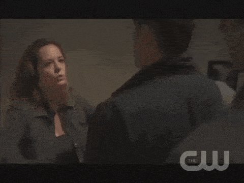 a close up of a man and a woman hugging with the cw logo in the background