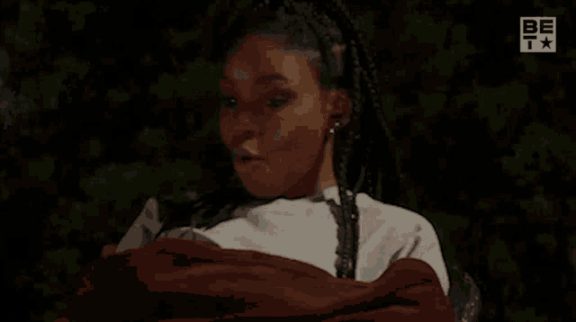 a woman is sitting in a chair wrapped in a red blanket with her mouth open .