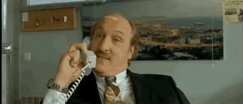 a man in a suit is talking on a phone