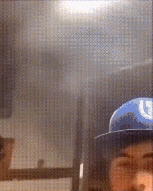 a man wearing a blue hat with a letter u on it