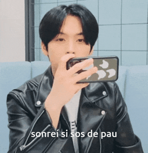 a man in a leather jacket is taking a picture of himself with his phone and the words sonrei si sos de pau below him