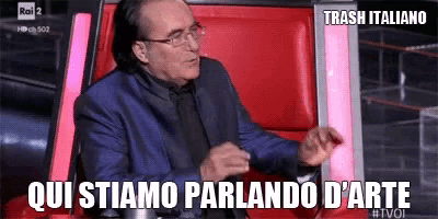 a man in a suit and glasses is sitting in a red chair with the words trash italiano above him .