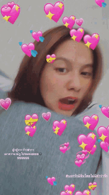 a girl is surrounded by pink hearts and the words # บอก รัก มี คน โดย ไม่มี คํา ว่า รัก are below her