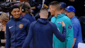 a group of basketball players are standing in the stands talking to each other