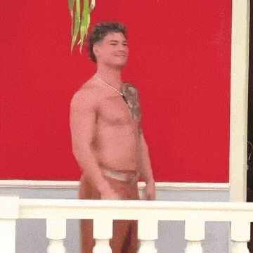 a shirtless man with a tattoo on his chest is standing on a balcony