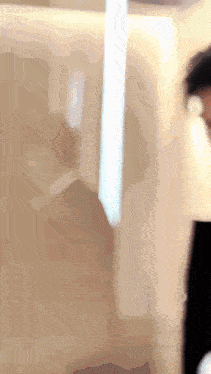 a blurred image of a person holding a white object in their hand