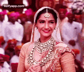 a woman in a wedding dress and veil is smiling at the camera .
