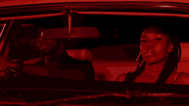 a man is driving a car with a woman in the back seat