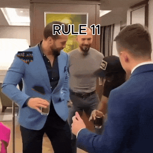 a man in a blue jacket holds a glass in front of two other men with rule 11 written above them