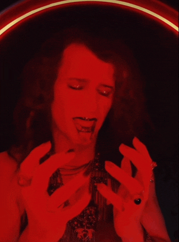 a woman in a red dress is holding her head in pain