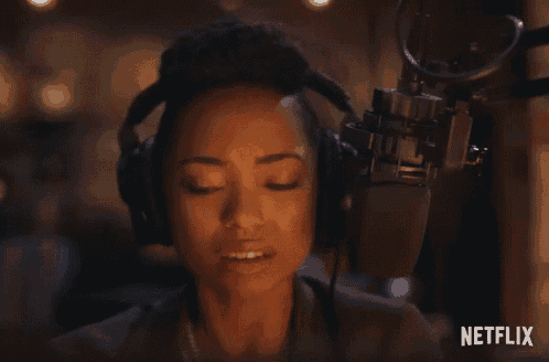 a woman wearing headphones speaking into a microphone with netflix written on the bottom right