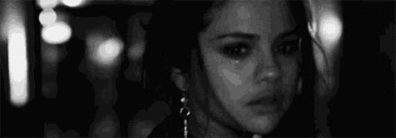 a black and white photo of a woman with tears running down her face .