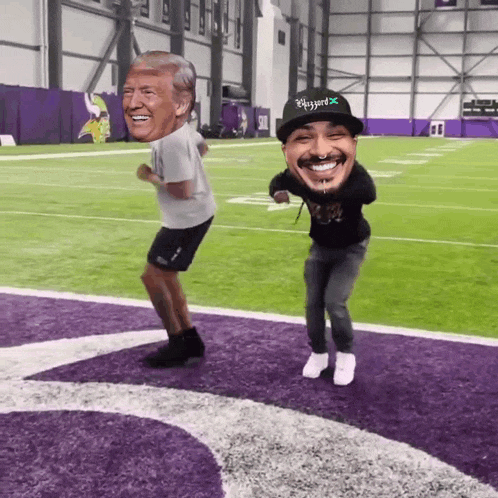 two men are dancing on a football field and one of them is wearing a hat that says flygard on it
