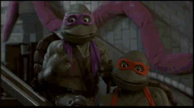 two teenage mutant ninja turtles are standing next to each other and smiling