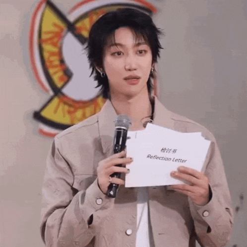 a young man holding a microphone and a piece of paper that says reflection letter