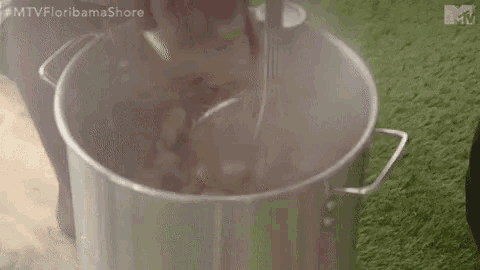 a person is stirring a pot of food with a spatula .
