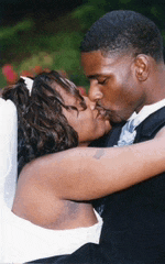 a bride and groom kissing in a garden